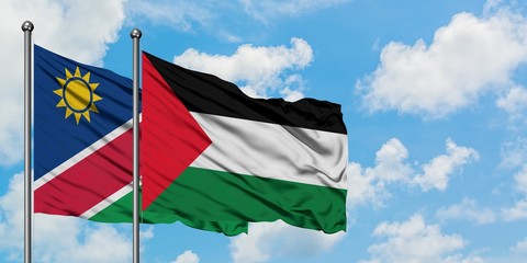 Namibia and Palestine flag waving in the wind against white cloudy blue sky together. Diplomacy concept, international relations.