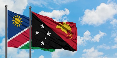 Namibia and Papua New Guinea flag waving in the wind against white cloudy blue sky together. Diplomacy concept, international relations.