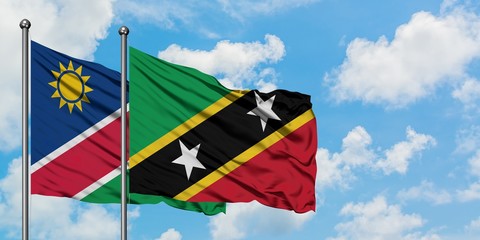 Namibia and Saint Kitts And Nevis flag waving in the wind against white cloudy blue sky together. Diplomacy concept, international relations.