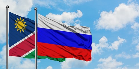 Namibia and Russia flag waving in the wind against white cloudy blue sky together. Diplomacy concept, international relations.