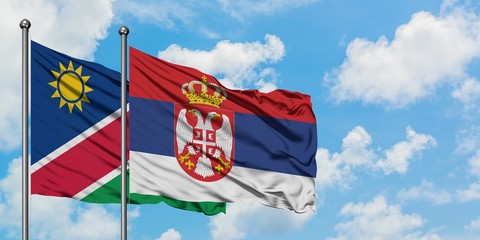 Namibia and Serbia flag waving in the wind against white cloudy blue sky together. Diplomacy concept, international relations.
