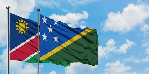 Namibia and Solomon Islands flag waving in the wind against white cloudy blue sky together. Diplomacy concept, international relations.