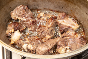 Lamb meat is fried in a pan