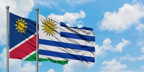 Namibia and Uruguay flag waving in the wind against white cloudy blue sky together. Diplomacy concept, international relations.