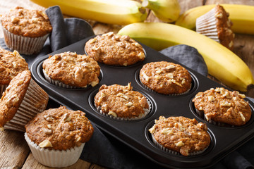 Freshly baked banana walnuts muffins close-up in a baking dish. horizontal