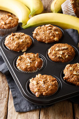 Banana nut muffins close-up in a baking dish. vertical