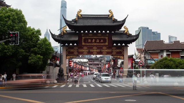 Timelapse Shanghai old street Lao jie with cars driving under ancient arch in pagoda style against modern skyscrapers in Chinese downtown