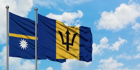 Nauru and Barbados flag waving in the wind against white cloudy blue sky together. Diplomacy concept, international relations.