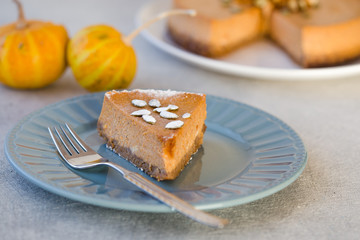 Pumpkin pie with caramel  on decorative plate. Whole pie in soft focus in background. Macro with shallow dof