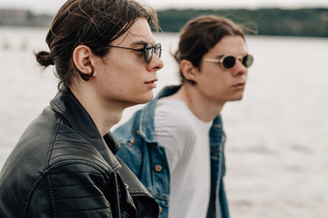 Two Stylish Twins Brothers Posing on the Pier Near the River