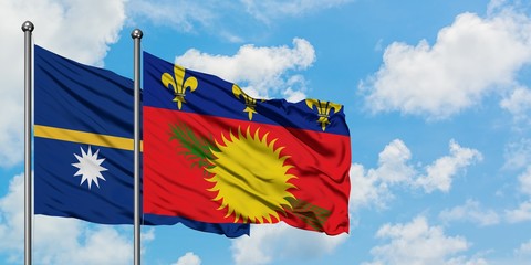 Nauru and Guadeloupe flag waving in the wind against white cloudy blue sky together. Diplomacy concept, international relations.
