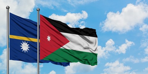 Nauru and Jordan flag waving in the wind against white cloudy blue sky together. Diplomacy concept, international relations.