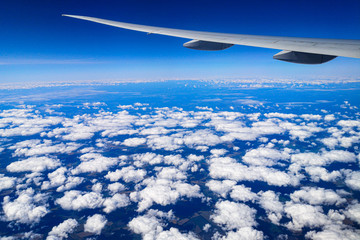Clouds above the ground view from an airplane as a background