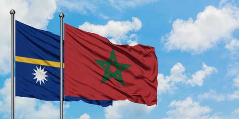 Nauru and Morocco flag waving in the wind against white cloudy blue sky together. Diplomacy concept, international relations.