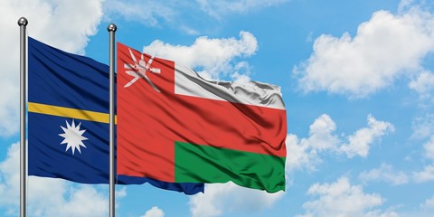Nauru and Oman flag waving in the wind against white cloudy blue sky together. Diplomacy concept, international relations.