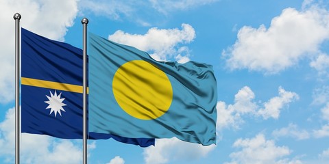 Nauru and Palau flag waving in the wind against white cloudy blue sky together. Diplomacy concept, international relations.