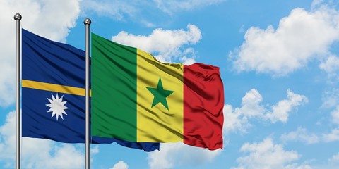 Nauru and Senegal flag waving in the wind against white cloudy blue sky together. Diplomacy concept, international relations.