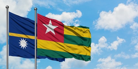 Nauru and Togo flag waving in the wind against white cloudy blue sky together. Diplomacy concept, international relations.