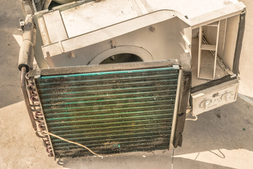 a professional electrician is cleaning the window air conditioner on the roof top of a house with his high pressure water gun   