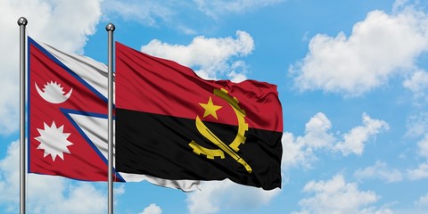 Nepal and Angola flag waving in the wind against white cloudy blue sky together. Diplomacy concept, international relations.