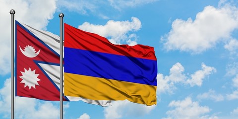 Nepal and Armenia flag waving in the wind against white cloudy blue sky together. Diplomacy concept, international relations.