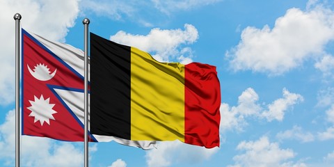 Nepal and Belgium flag waving in the wind against white cloudy blue sky together. Diplomacy concept, international relations.