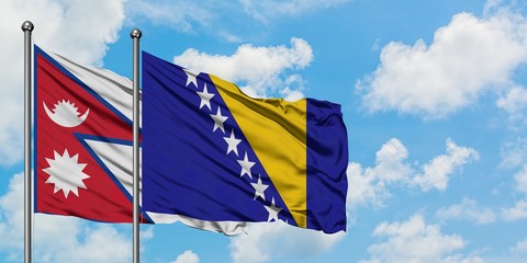 Nepal and Bosnia Herzegovina flag waving in the wind against white cloudy blue sky together. Diplomacy concept, international relations.