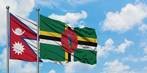 Nepal and Dominica flag waving in the wind against white cloudy blue sky together. Diplomacy concept, international relations.