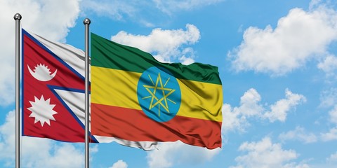 Nepal and Ethiopia flag waving in the wind against white cloudy blue sky together. Diplomacy concept, international relations.