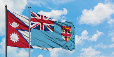 Nepal and Fiji flag waving in the wind against white cloudy blue sky together. Diplomacy concept, international relations.