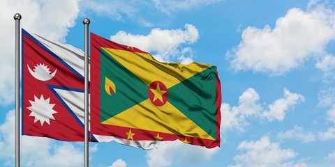 Nepal and Grenada flag waving in the wind against white cloudy blue sky together. Diplomacy concept, international relations.