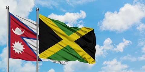 Nepal and Jamaica flag waving in the wind against white cloudy blue sky together. Diplomacy concept, international relations.