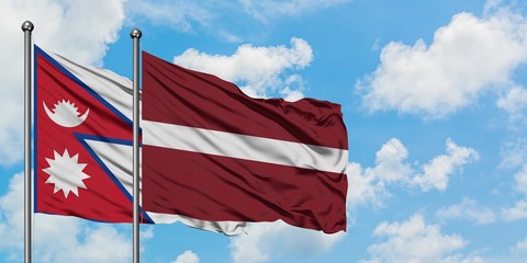 Nepal and Latvia flag waving in the wind against white cloudy blue sky together. Diplomacy concept, international relations.