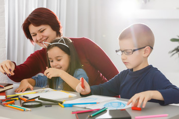 Teacher and kids lying on floor using digital tablet in library at elementary school