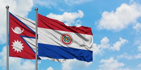 Nepal and Paraguay flag waving in the wind against white cloudy blue sky together. Diplomacy concept, international relations.
