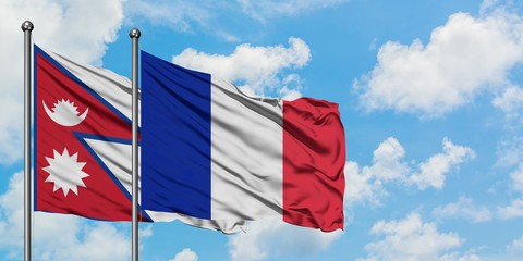 Nepal and Reunion flag waving in the wind against white cloudy blue sky together. Diplomacy concept, international relations.