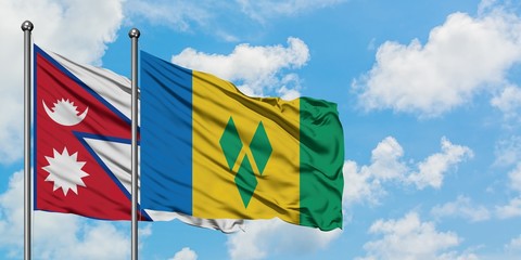 Nepal and Saint Vincent And The Grenadines flag waving in the wind against white cloudy blue sky...