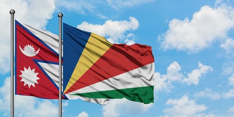 Nepal and Seychelles flag waving in the wind against white cloudy blue sky together. Diplomacy concept, international relations.