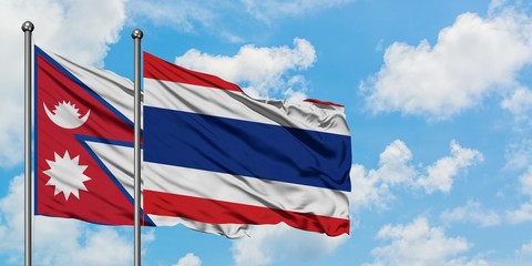 Nepal and Thailand flag waving in the wind against white cloudy blue sky together. Diplomacy concept, international relations.