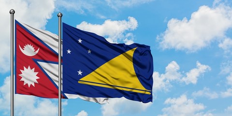Nepal and Tokelau flag waving in the wind against white cloudy blue sky together. Diplomacy concept, international relations.