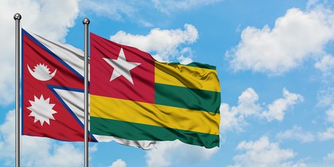 Nepal and Togo flag waving in the wind against white cloudy blue sky together. Diplomacy concept, international relations.