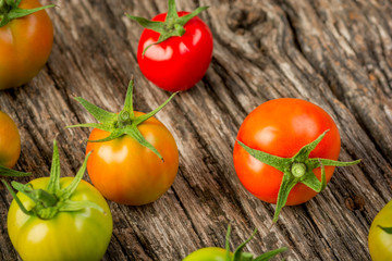 Colorful tomatoes on a wooden surface close up. Healthy organic food.