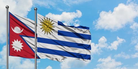 Nepal and Uruguay flag waving in the wind against white cloudy blue sky together. Diplomacy concept, international relations.