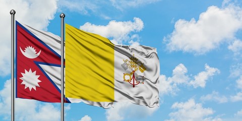 Nepal and Vatican City flag waving in the wind against white cloudy blue sky together. Diplomacy concept, international relations.