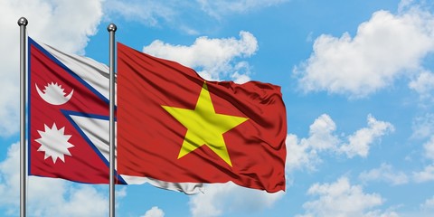 Nepal and Vietnam flag waving in the wind against white cloudy blue sky together. Diplomacy concept, international relations.
