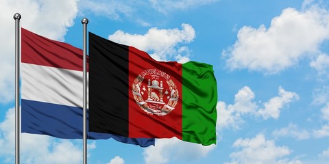 Netherlands and Afghanistan flag waving in the wind against white cloudy blue sky together. Diplomacy concept, international relations.