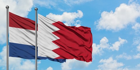 Netherlands and Bahrain flag waving in the wind against white cloudy blue sky together. Diplomacy concept, international relations.