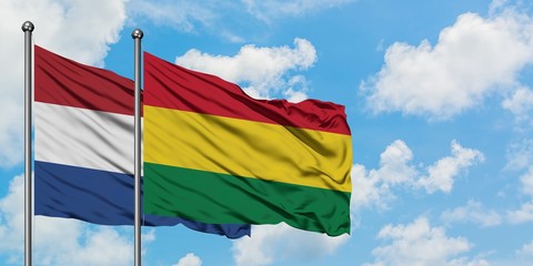 Netherlands and Bolivia flag waving in the wind against white cloudy blue sky together. Diplomacy concept, international relations.