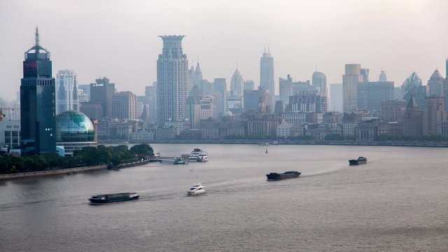 Timelapse central Shanghai embankment area Waitan with historical and modern buildings at Huangpu river with sailing ships in early morning in China