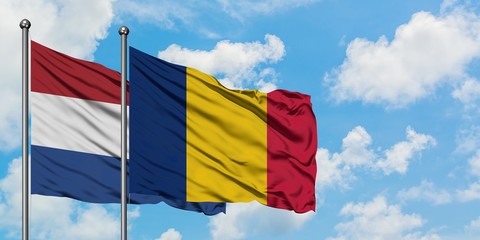 Netherlands and Chad flag waving in the wind against white cloudy blue sky together. Diplomacy concept, international relations.